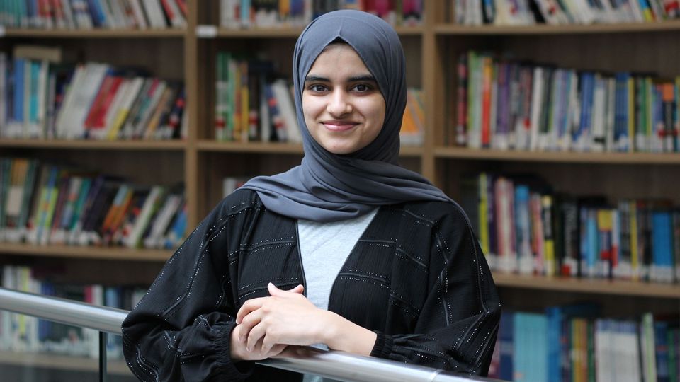 Student in front of book case