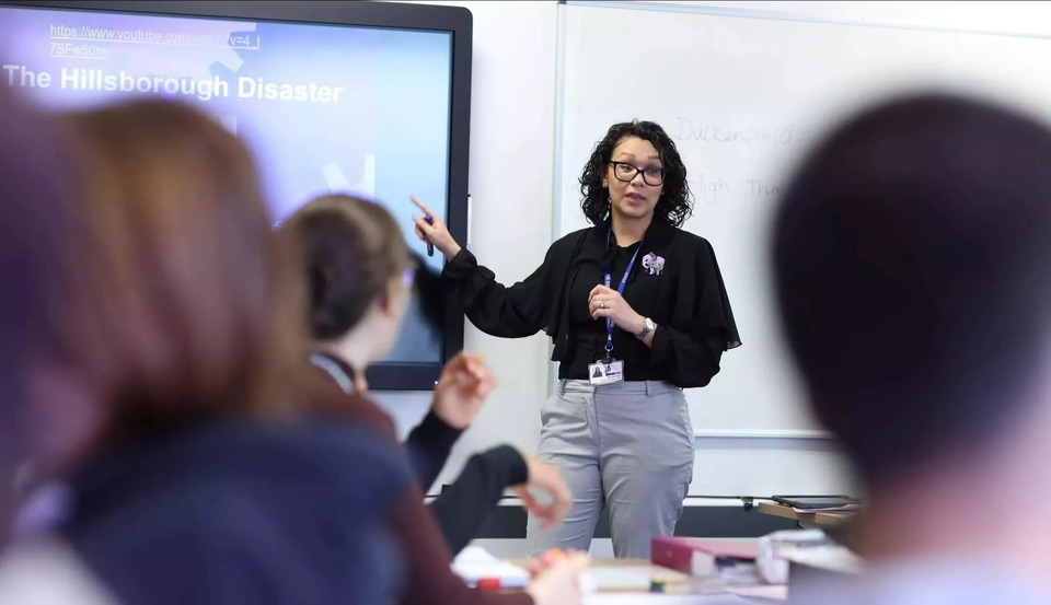 Staff teaching a lesson in front of a screen