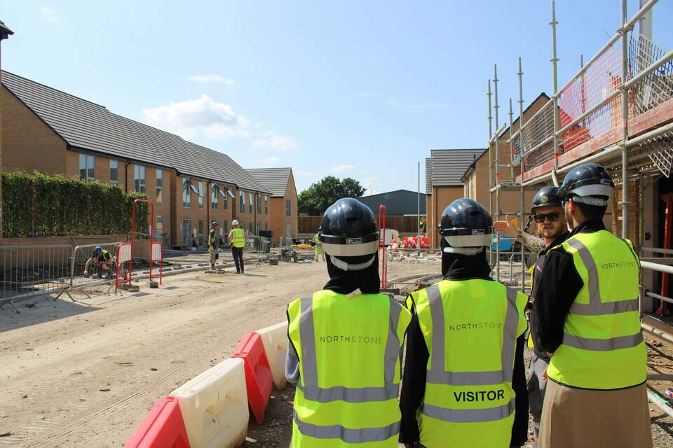 Students on a building site with employer