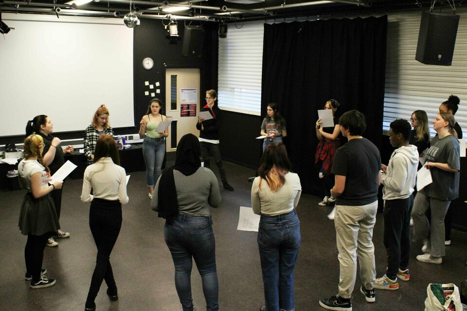 Studentsstanding in circle performing