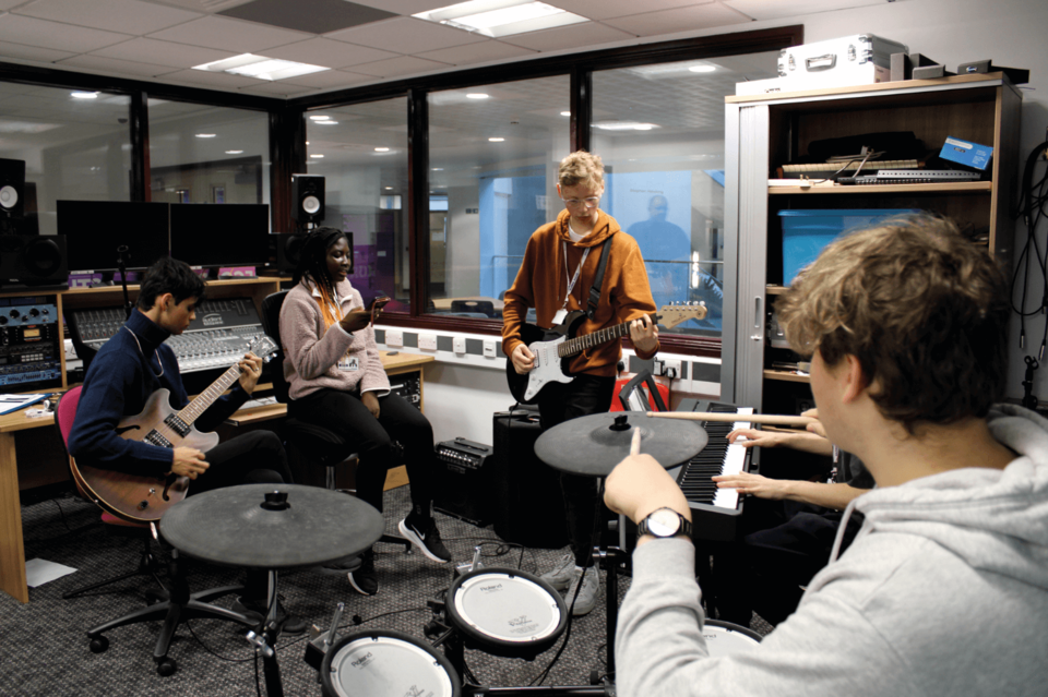 Image of students playing instruments in the music suite