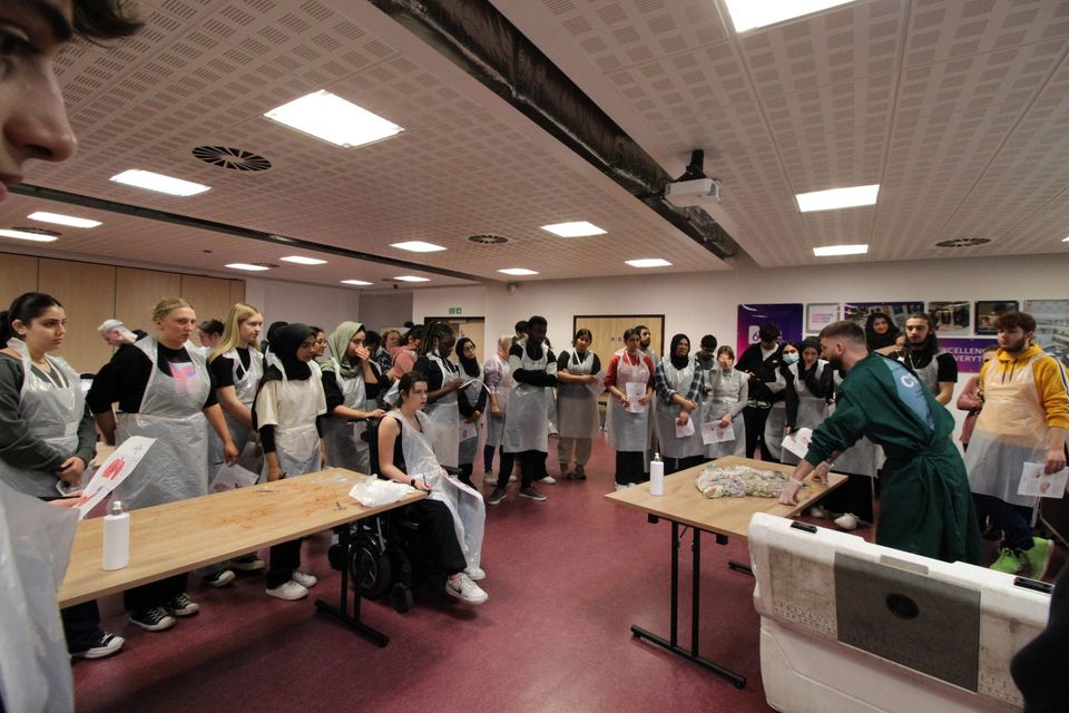 Students watching presenter perform dissection