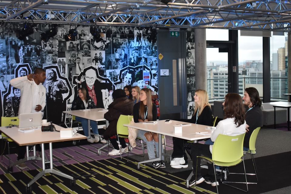 Students at desk with man delivering session