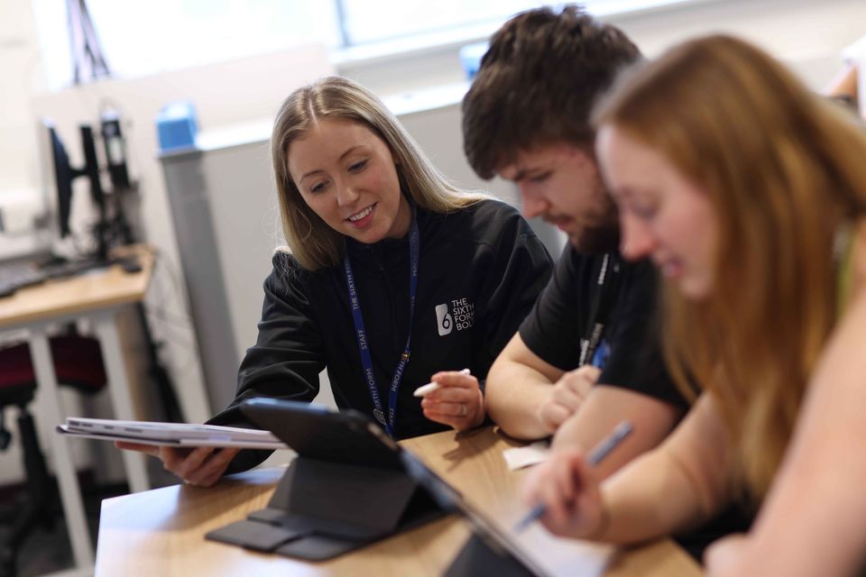 Image of teacher with two students using an iPad Image of teacher with two students using an iPad